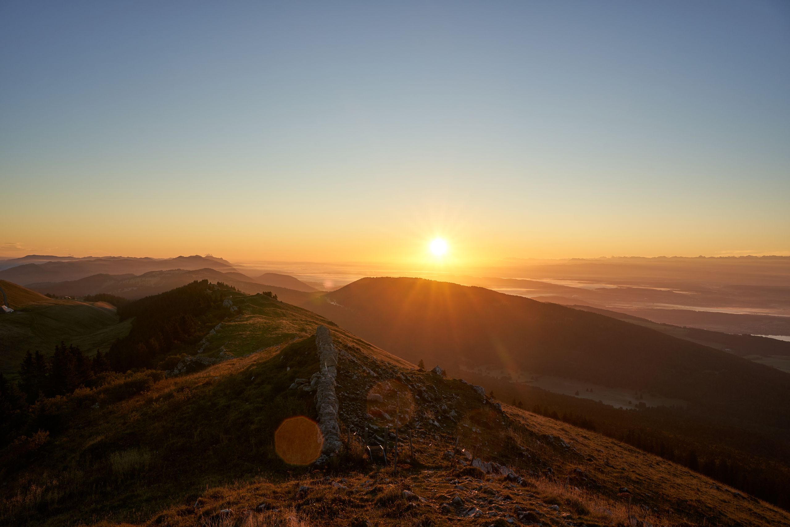 Breathtaking sunrise view over mountainous landscape in Switzerland, capturing nature's beauty.